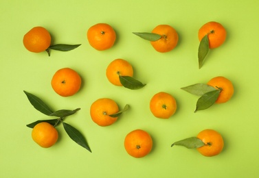 Photo of Composition with tangerines and leaves on color background, flat lay