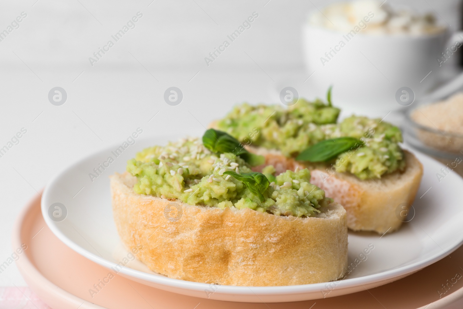 Photo of Plate with delicious avocado sandwiches on table