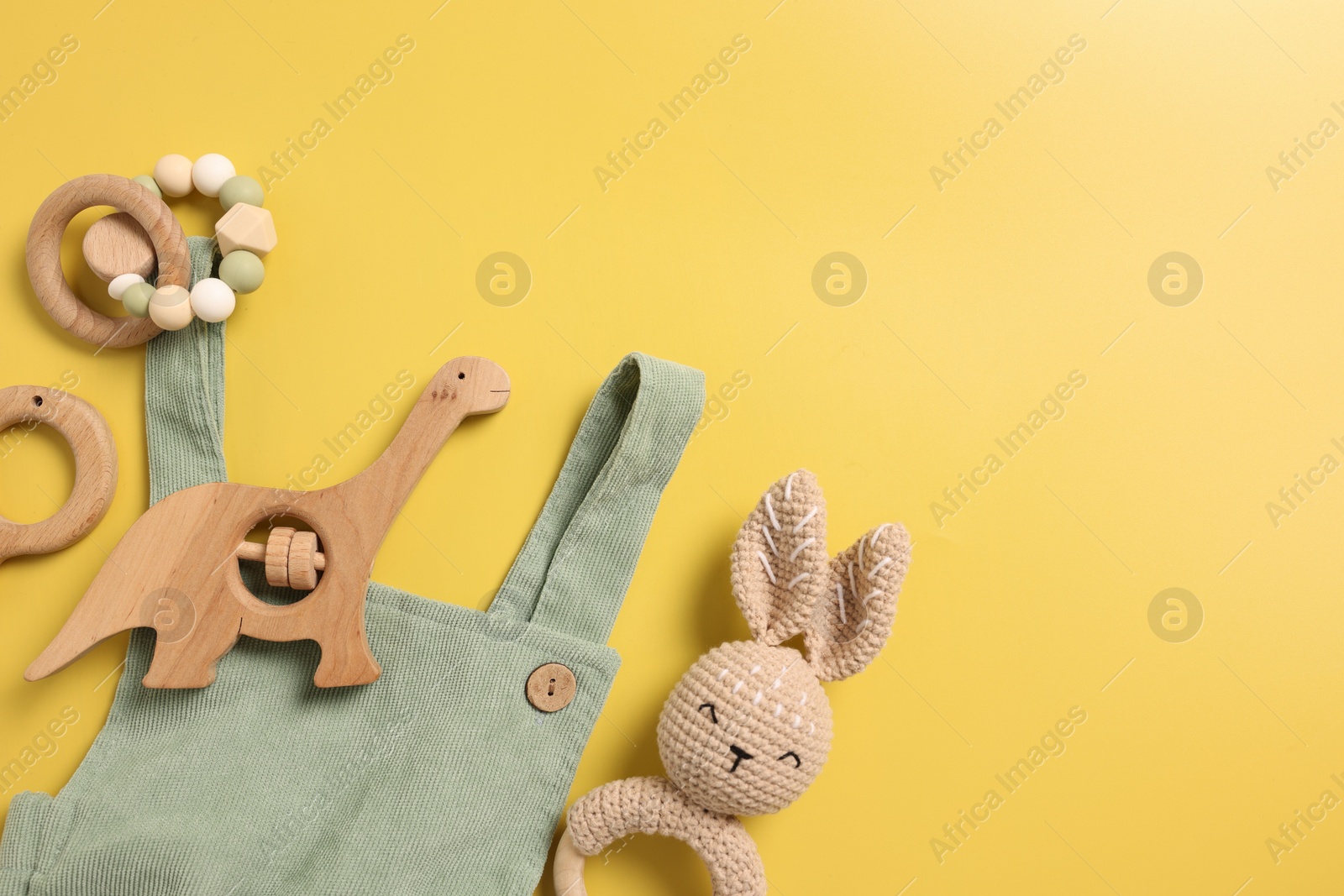 Photo of Different baby accessories on yellow background, flat lay. Space for text