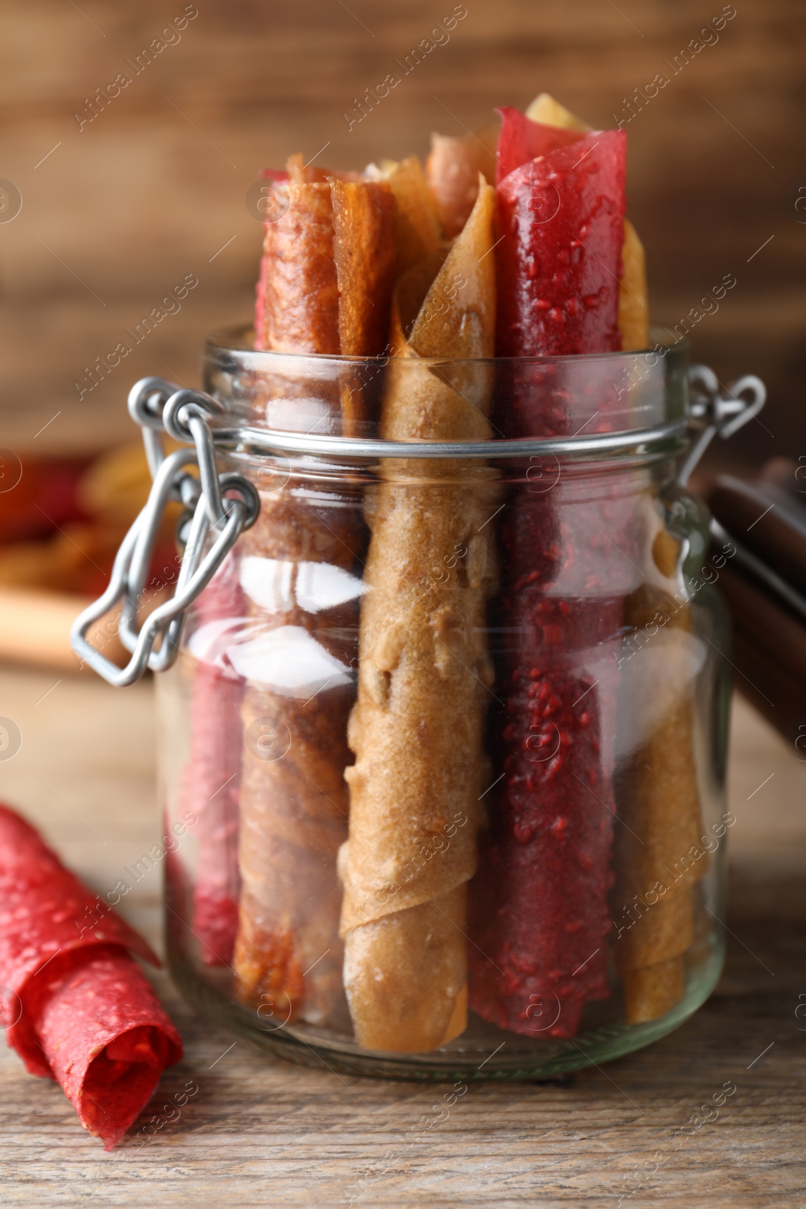 Photo of Delicious fruit leather rolls on wooden table