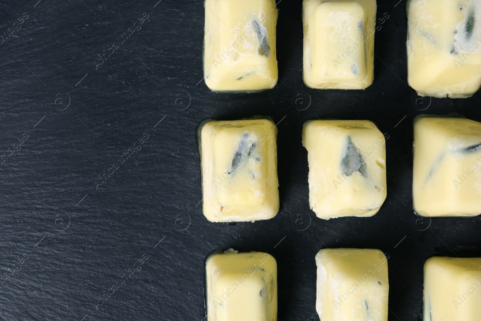 Photo of Flat lay composition with rosemary and olive oil ice cubes on dark background