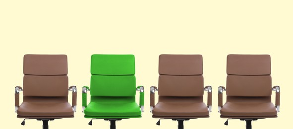 Image of Vacant position. Green office chair among brown ones on beige background, banner design