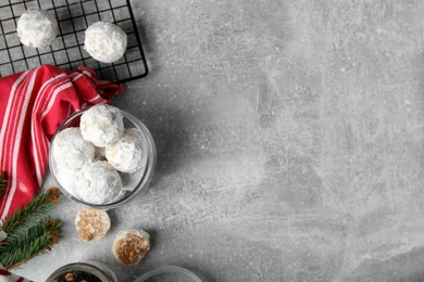 Flat lay composition with Christmas snowball cookies on grey table, space for text