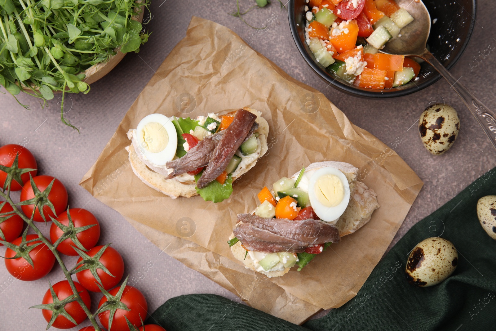 Photo of Delicious bruschettas with anchovies, eggs, cream cheese, tomatoes, bell peppers and cucumbers on grey table, flat lay