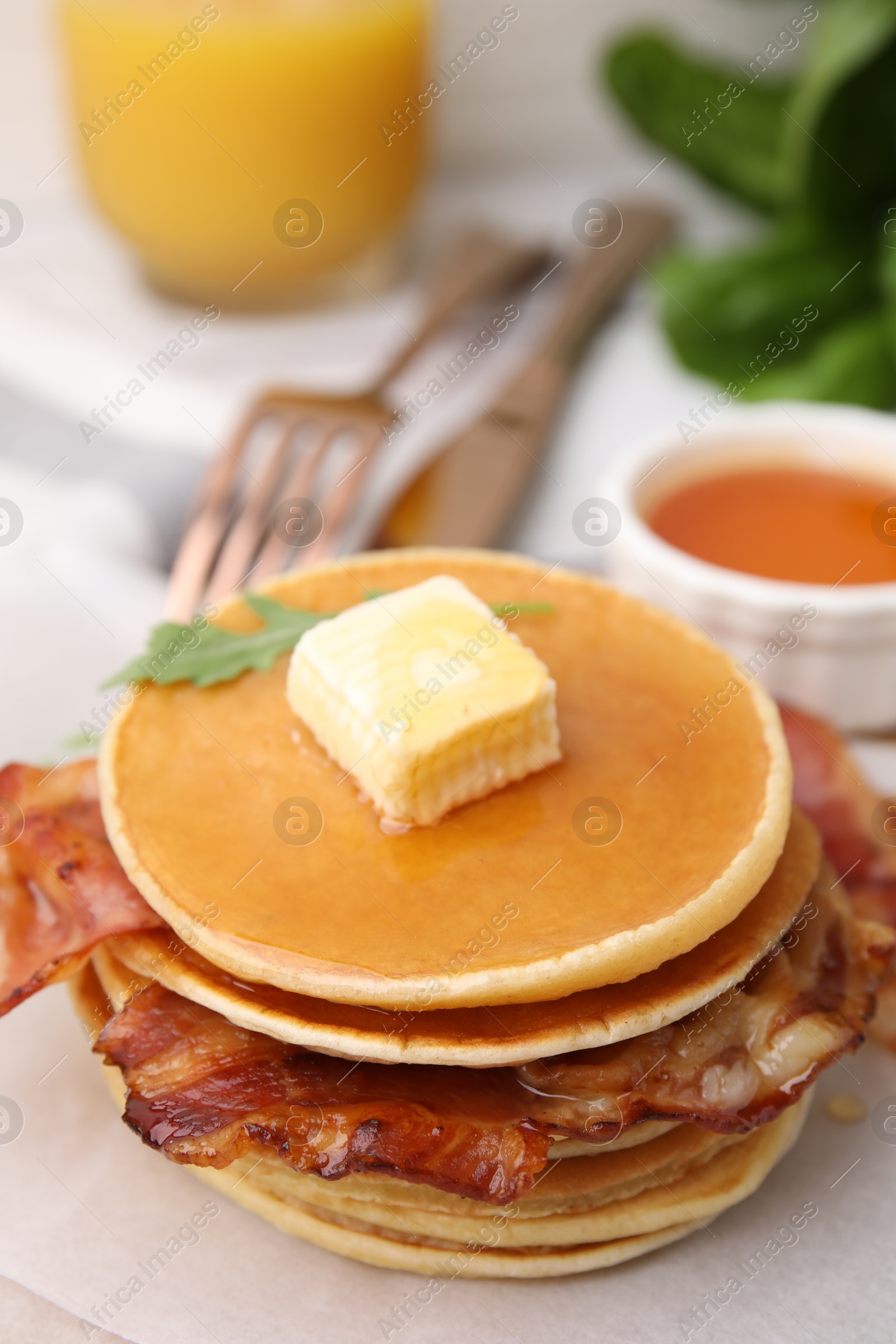 Photo of Delicious pancakes with bacon, butter and honey on table, closeup