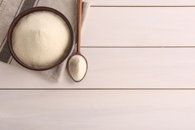 Photo of Uncooked organic semolina on white wooden table, flat lay. Space for text