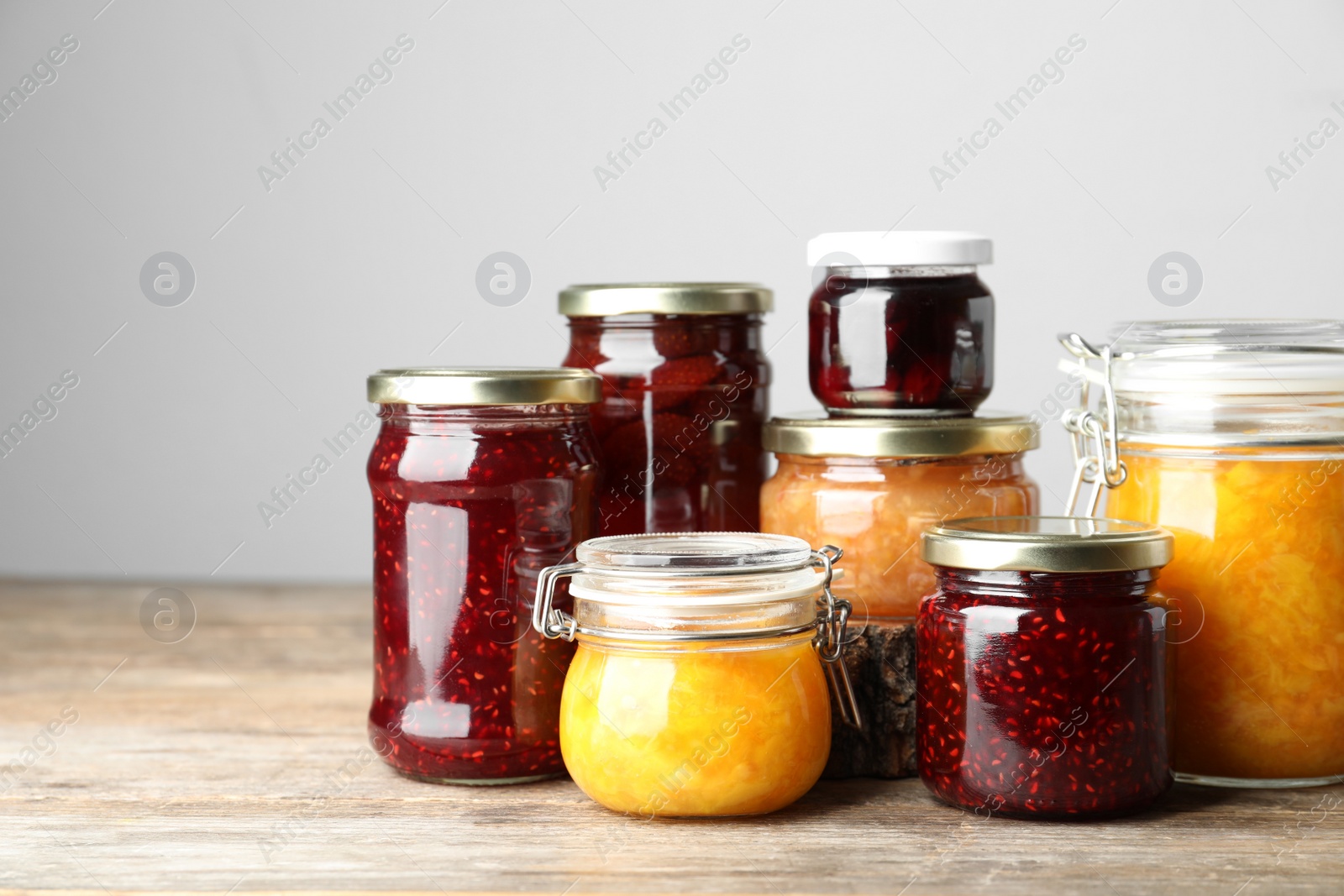 Photo of Jars with different jams on wooden table