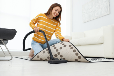 Young woman using vacuum cleaner at home