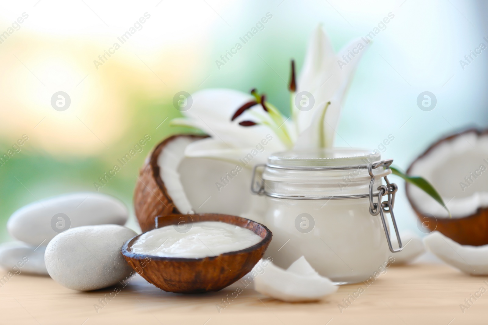 Photo of Composition with coconut butter in glass jar and shell on blurred background