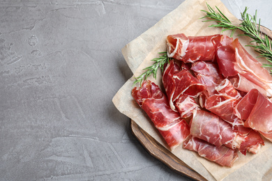 Photo of Tasty prosciutto on grey table, top view. Space for text