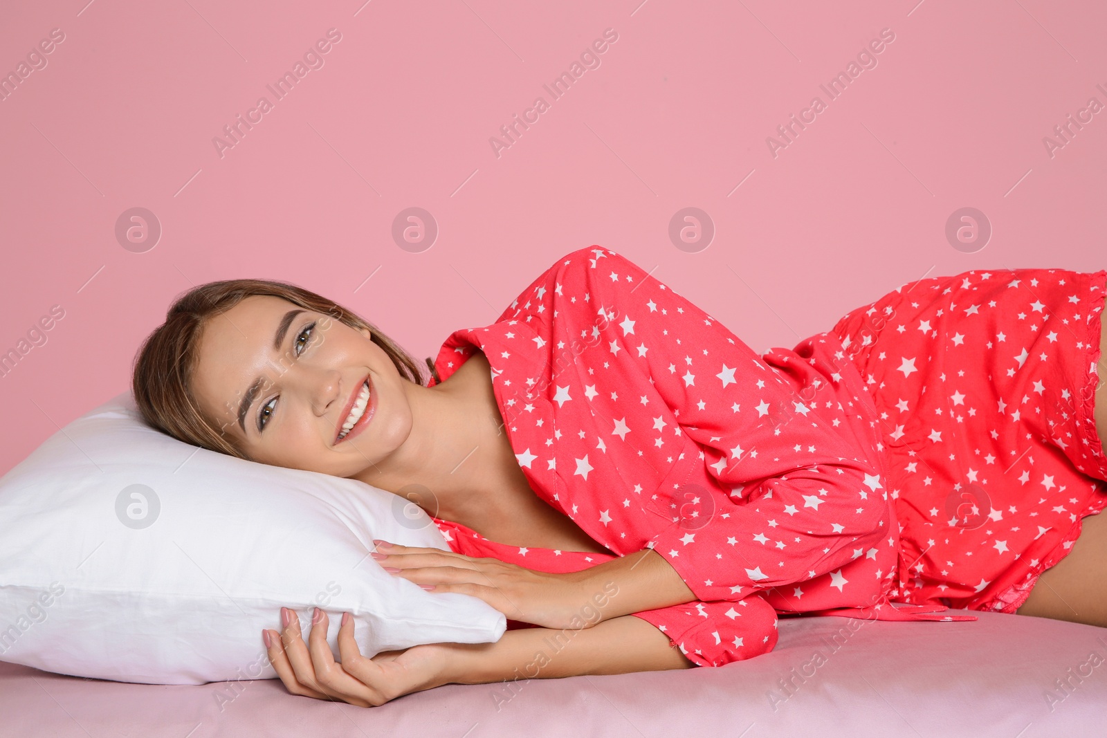 Photo of Beautiful teen girl lying with comfortable pillow on bed against color background