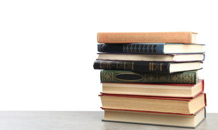 Photo of Stack of old vintage books on stone table against white background