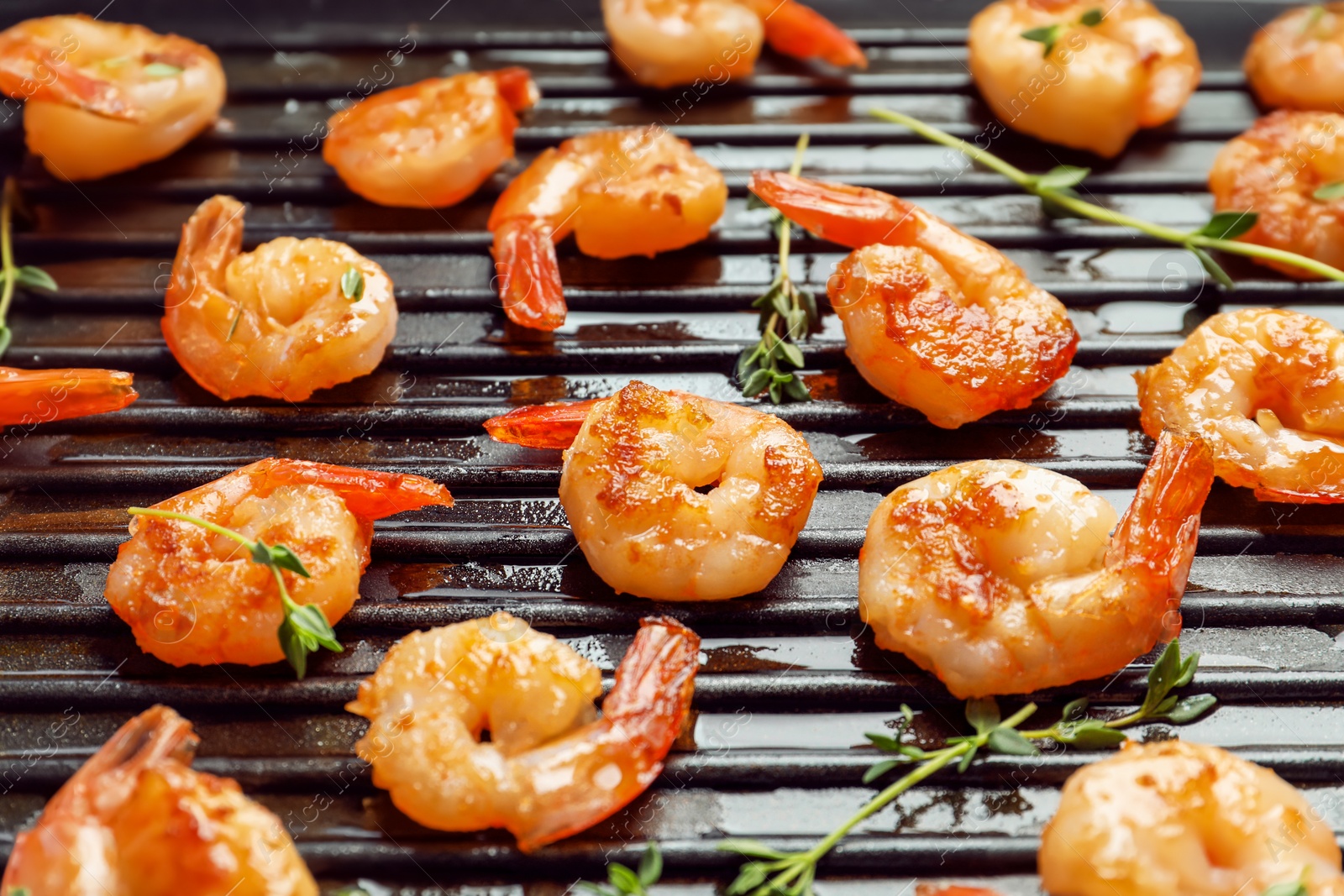 Photo of Delicious fried shrimps in grill pan, closeup