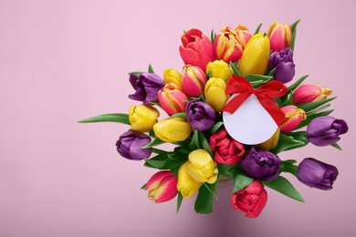 Photo of Bouquet of beautiful colorful tulips with blank card on beige background, top view and space for text. Birthday celebration