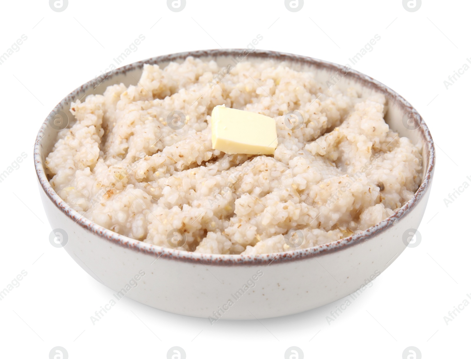 Photo of Delicious barley porridge with butter in bowl isolated on white