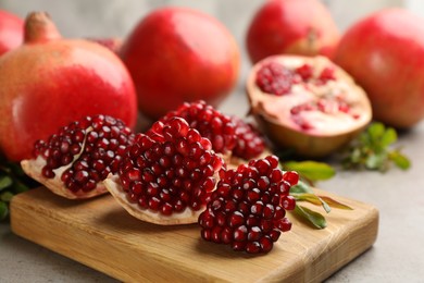 Delicious ripe pomegranates on grey table, closeup