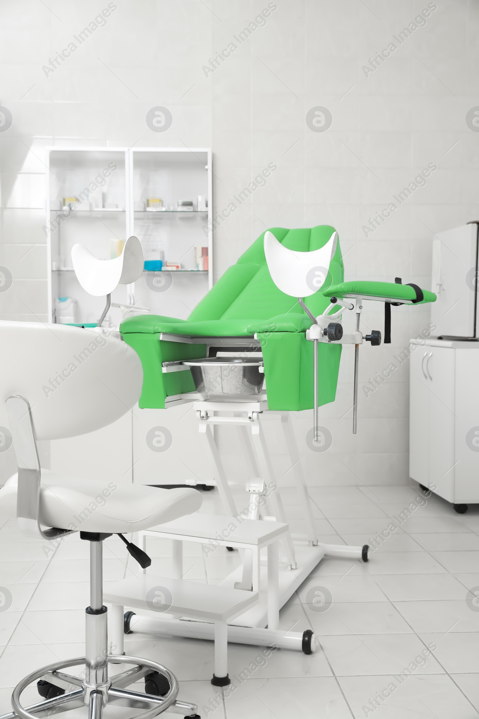 Photo of Modern gynecological office interior with examination chair and medical equipment