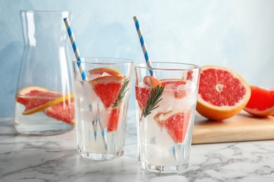 Photo of Glasses of infused water with grapefruit slices on table