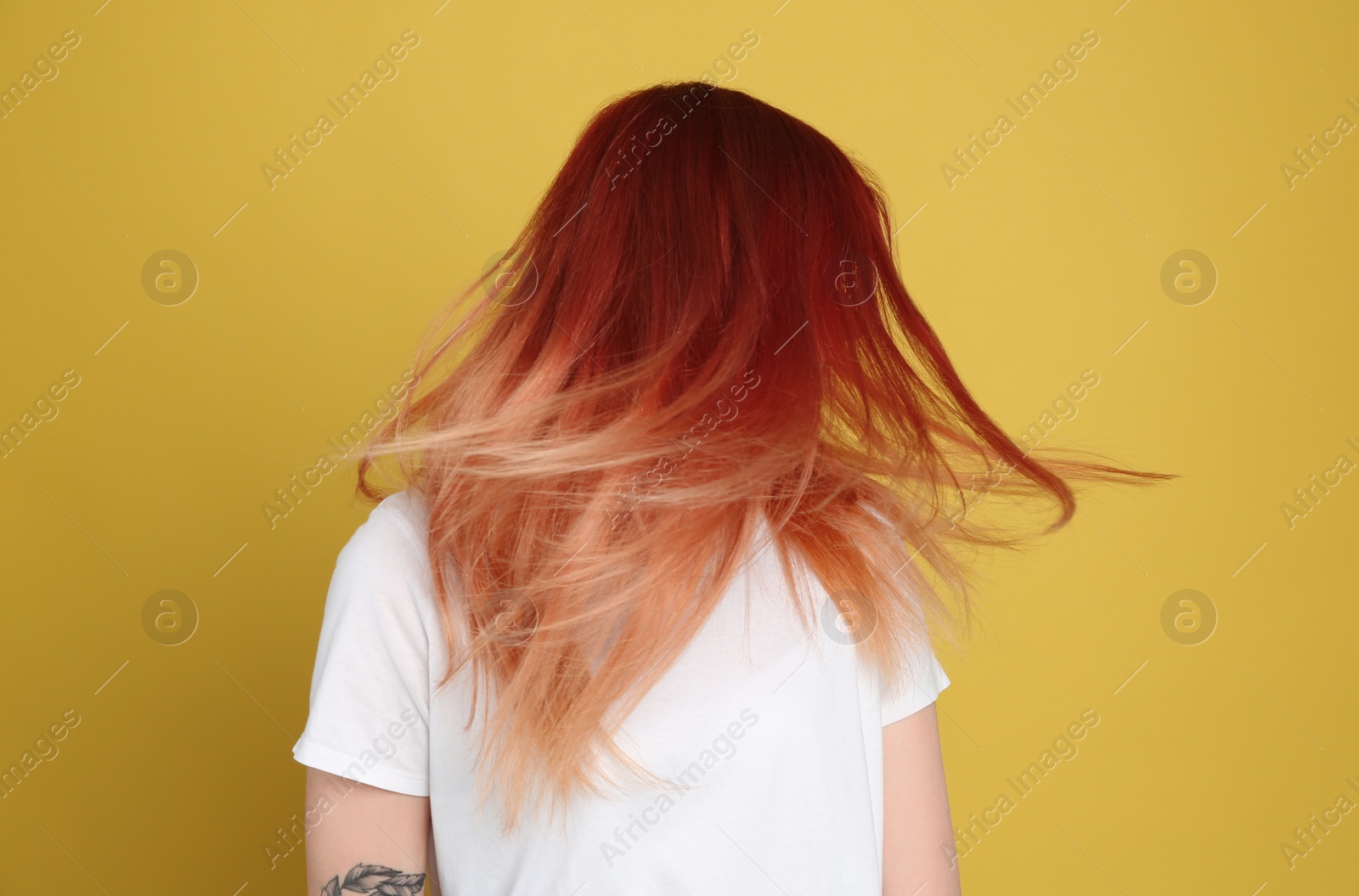 Photo of Young woman with bright dyed hair on yellow background