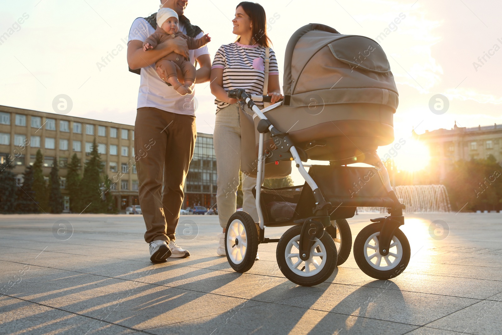 Photo of Happy parents walking with their baby outdoors