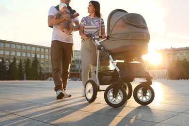 Photo of Happy parents walking with their baby outdoors
