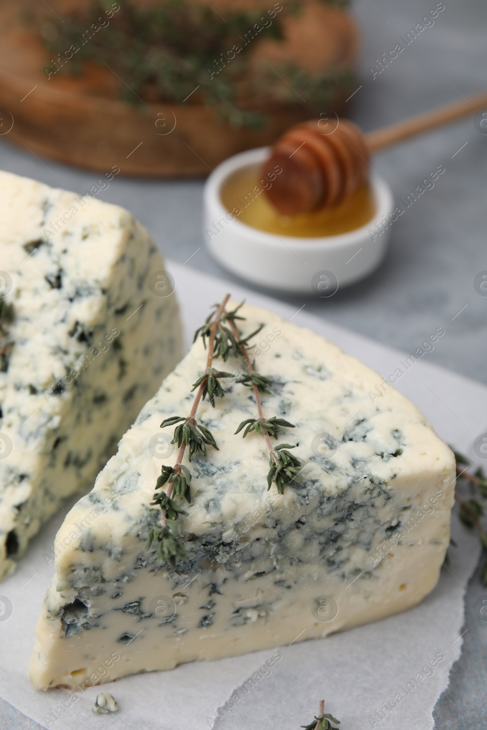 Photo of Tasty blue cheese with thyme on grey table