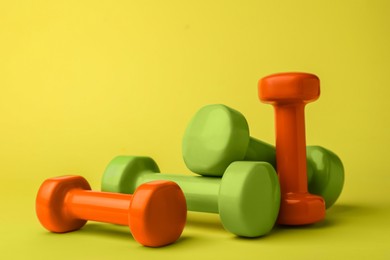 Photo of Many different stylish dumbbells on light green background