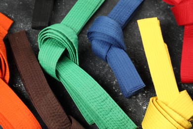 Photo of Colorful karate belts on gray background, closeup