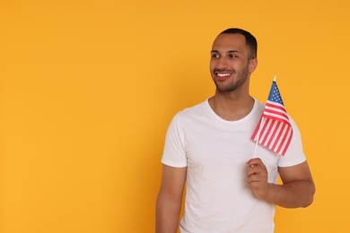 4th of July - Independence Day of USA. Happy man with American flag on yellow background, space for text