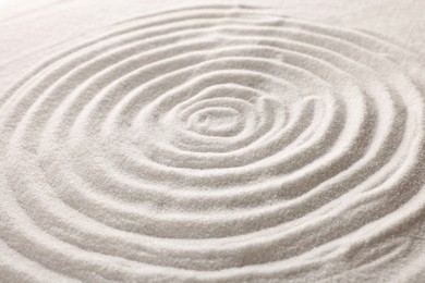 Photo of Pattern drawn on white sand, closeup. Zen garden