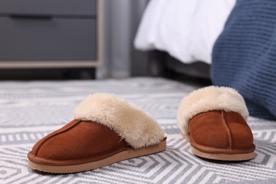 Photo of Brown soft slippers on carpet indoors, closeup