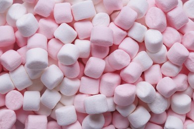Photo of Delicious puffy pink and white marshmallows as background, top view