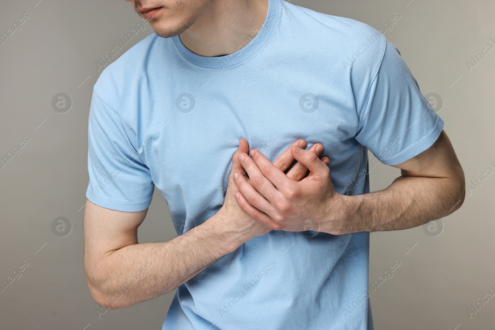 Photo of Man suffering from heart hurt on grey background, closeup