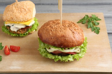 Photo of Delicious vegetarian burgers served on grey wooden table