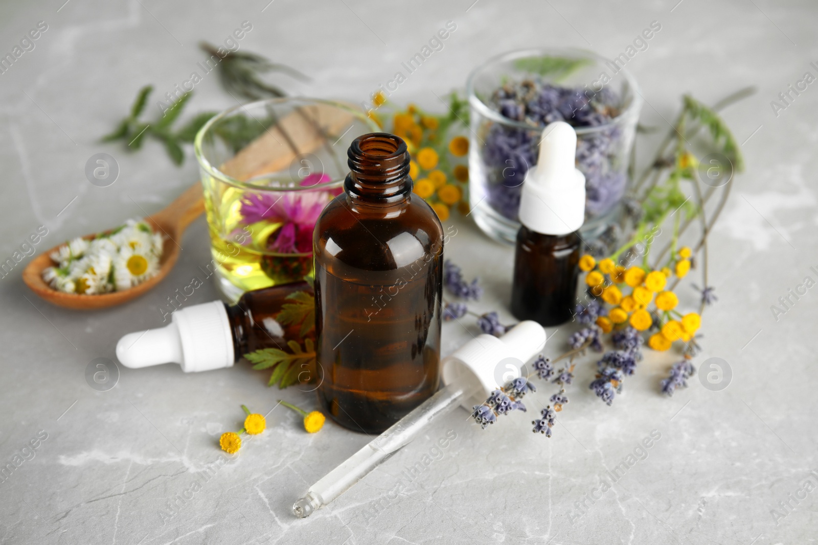 Photo of Composition with essential oils and flowers on table