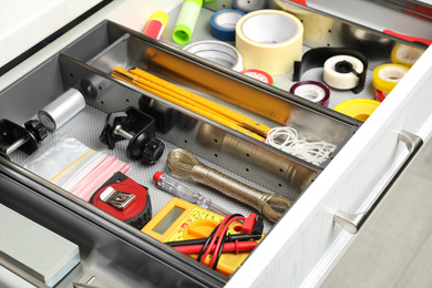 Set of instruments in open desk drawer indoors, closeup