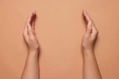 Photo of Woman holding on coral background, closeup of hands. Space for text