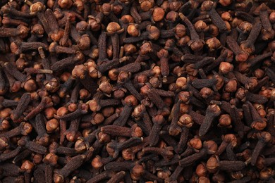 Photo of Many aromatic cloves as background, top view