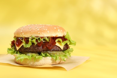 Photo of Burger with delicious patty on yellow background, space for text