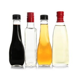 Photo of Bottles with different kinds of vinegar on white background