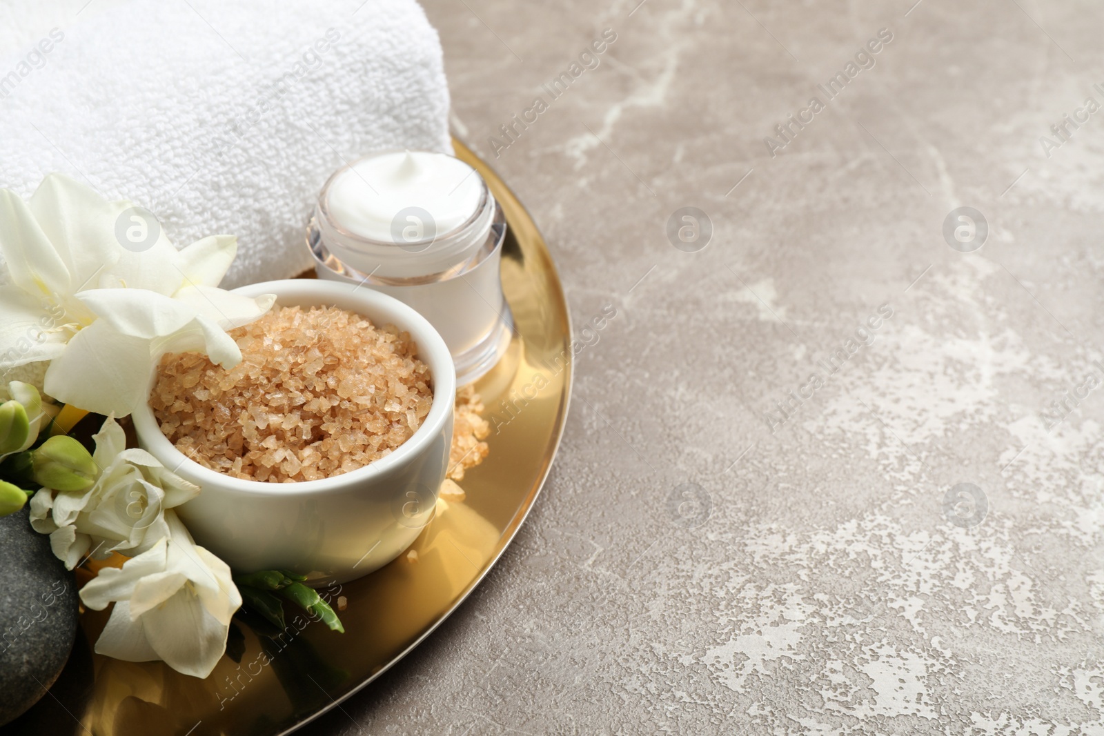 Photo of Spa composition with sea salt on grey marble table, space for text