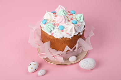 Traditional Easter cake with meringues and painted eggs on pink background