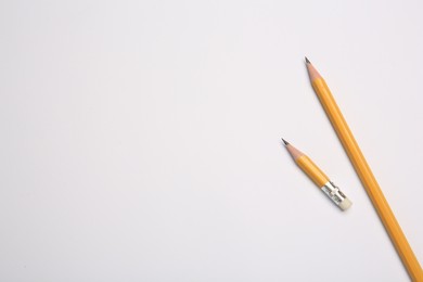 Photo of Graphite pencils on white background, flat lay. Space for text