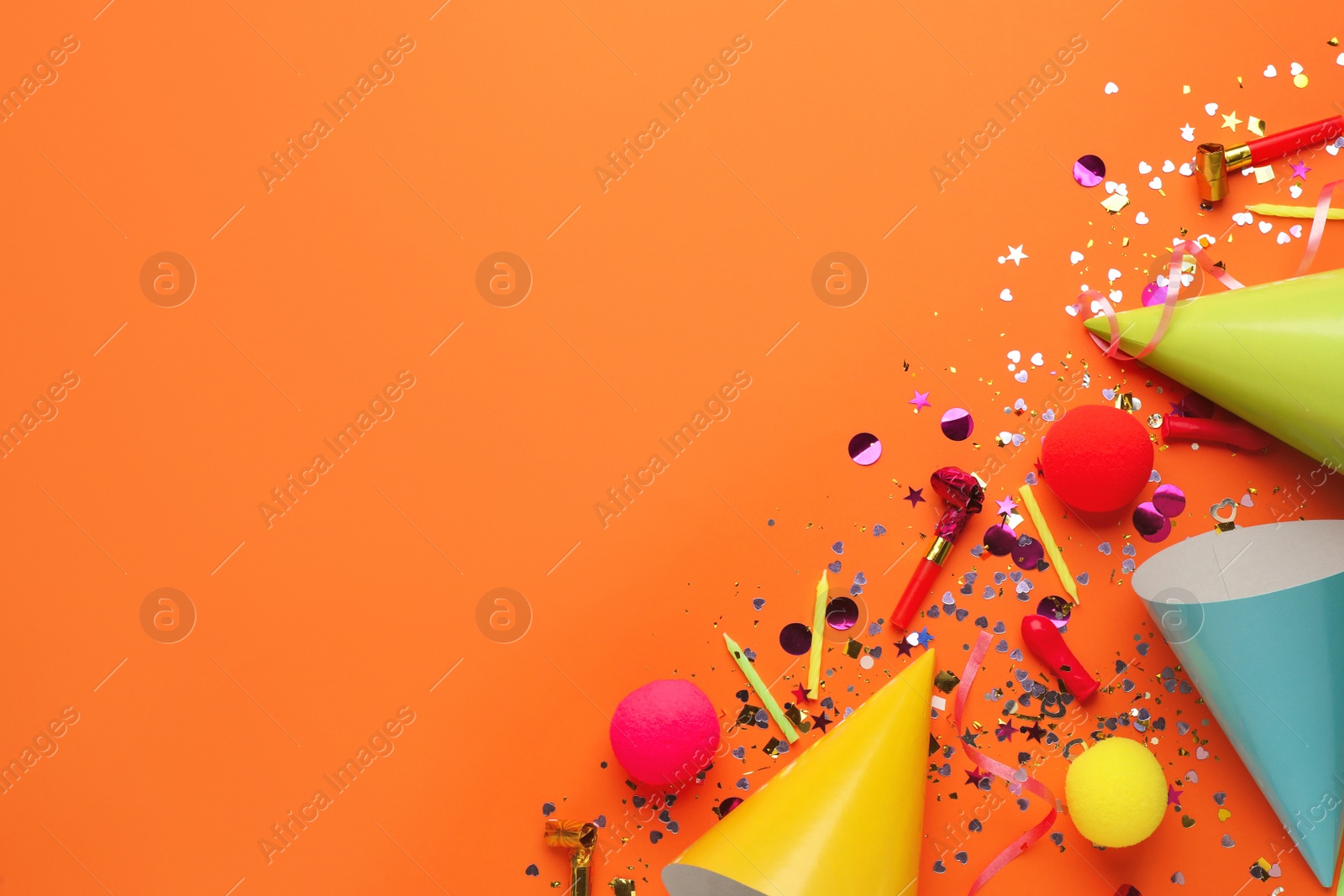 Photo of Beautiful flat lay composition with festive items on orange background, space for text. Surprise party concept