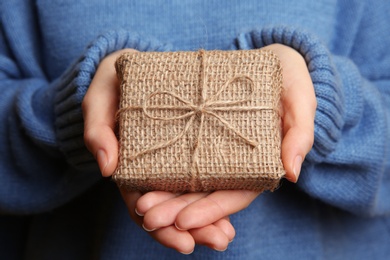 Photo of Woman in blue sweater holding Christmas gift box, closeup