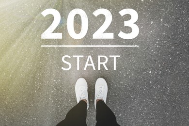 Start new year with fresh vision and ideas. 2021 numbers on asphalt road in front of woman, top view