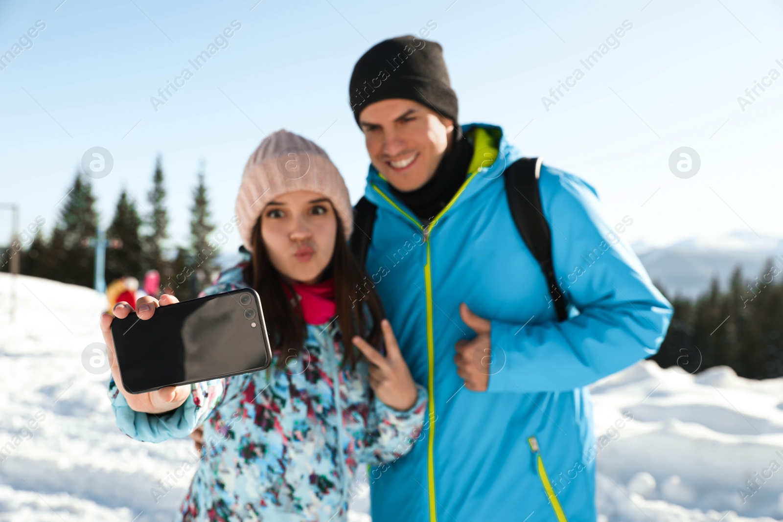 Photo of Happy couple taking selfie in mountains. Winter vacation