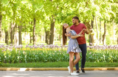 Happy young couple in green park on sunny spring day