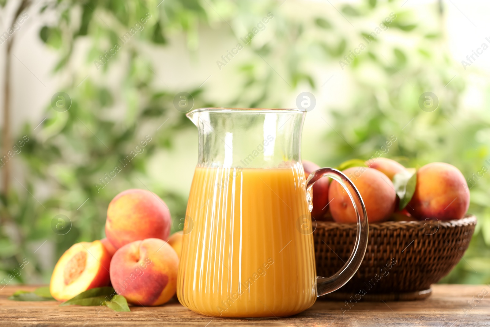 Photo of Natural peach juice and fresh fruits on wooden table