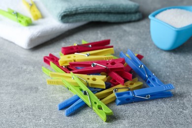 Photo of Colorful plastic clothespins on grey table, closeup